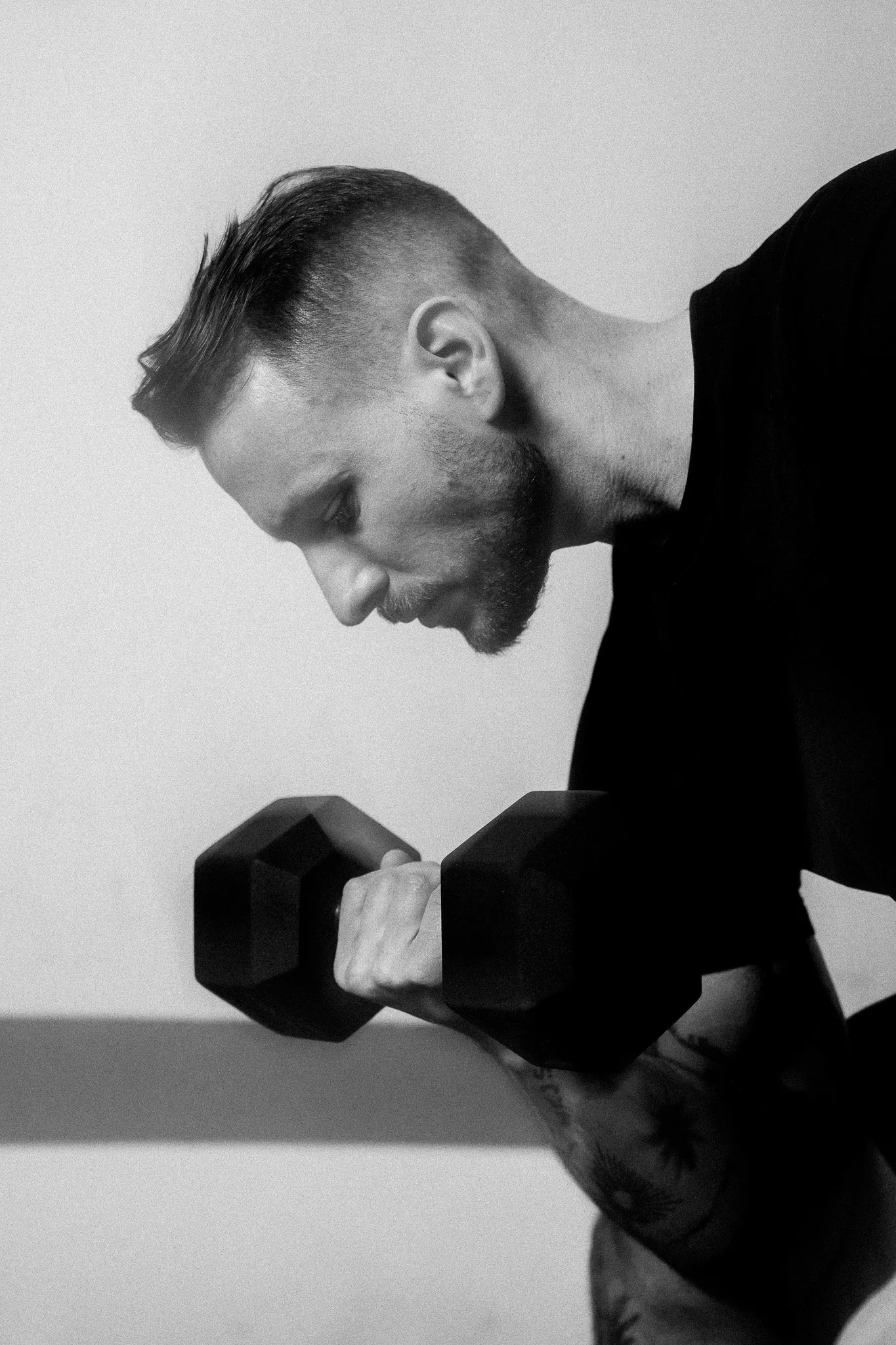 Trainer und CEO Niklas Schmid beim konzentrierten Kurzhanteltraining im Studio – Personal Training bei FORM-ID.