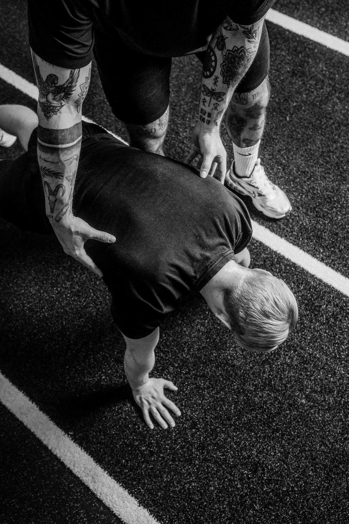 Individuelles Personal Training bei FORM-ID – Trainer korrigiert Haltung während einer Liegestütz-Übung im Studio.