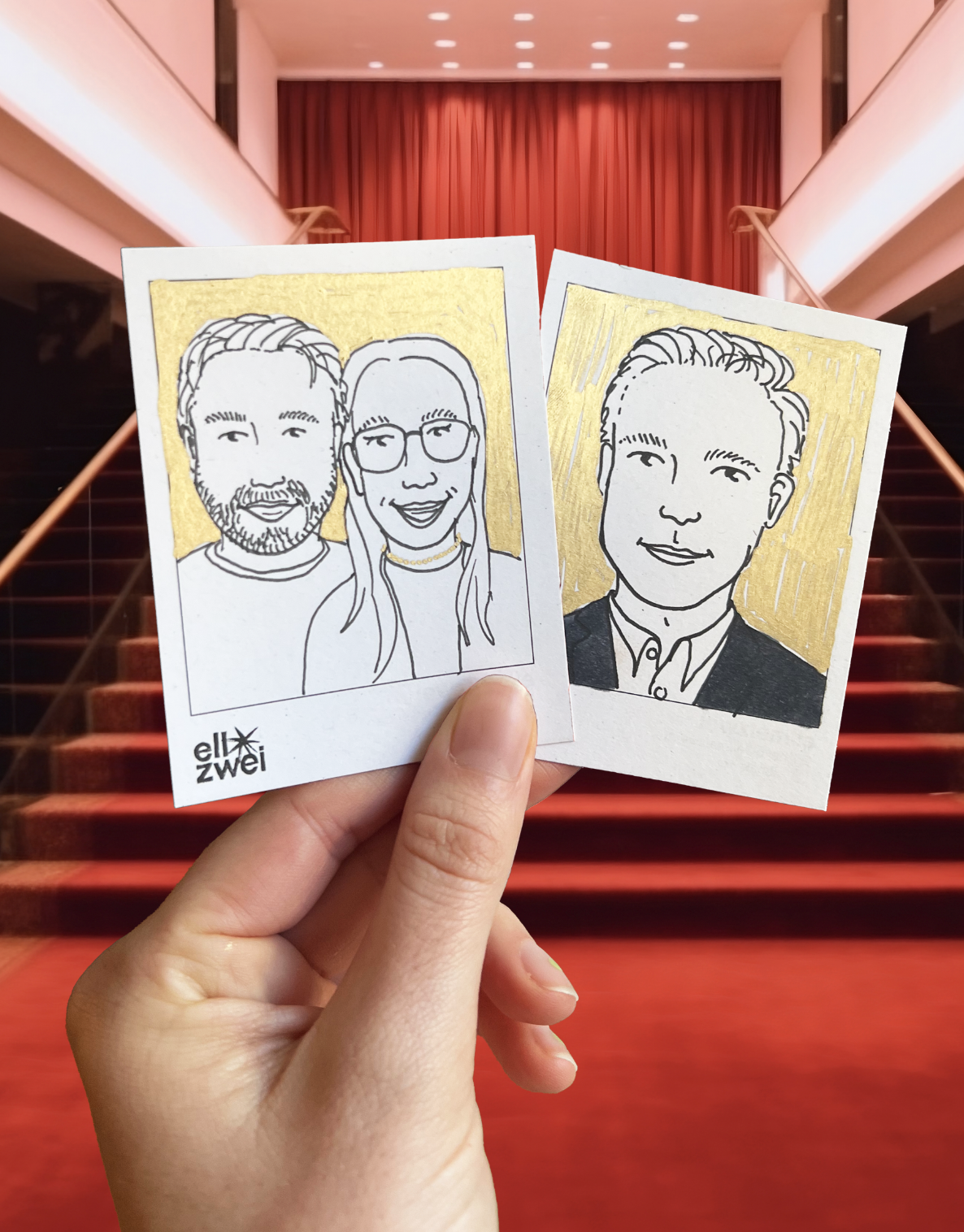 Zwei handgezeichnete Portraits mit schwarzem Fineliner mit goldenem Hintergrund werden in einer Hand vor rotem Teppich und Vorhang gehalten.