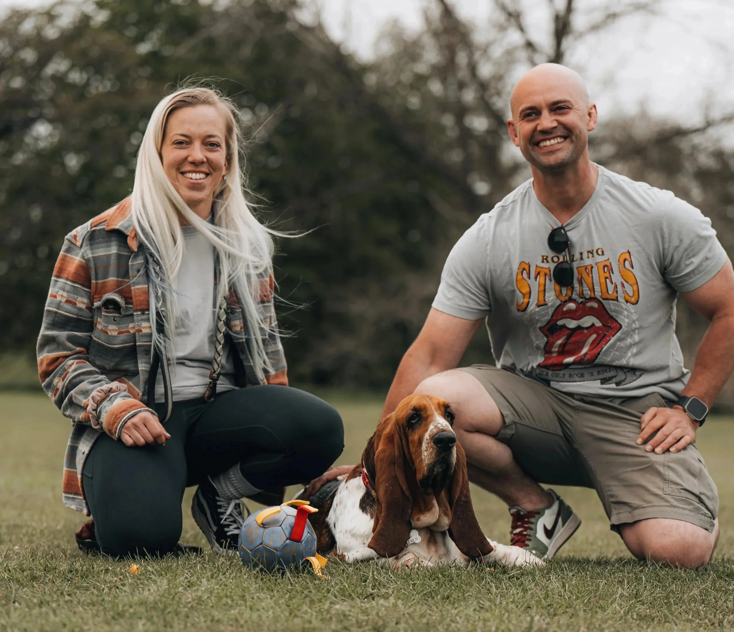 The two of us with our basset hound, capturing the warm, family‑run team behind our bespoke fitted furniture.