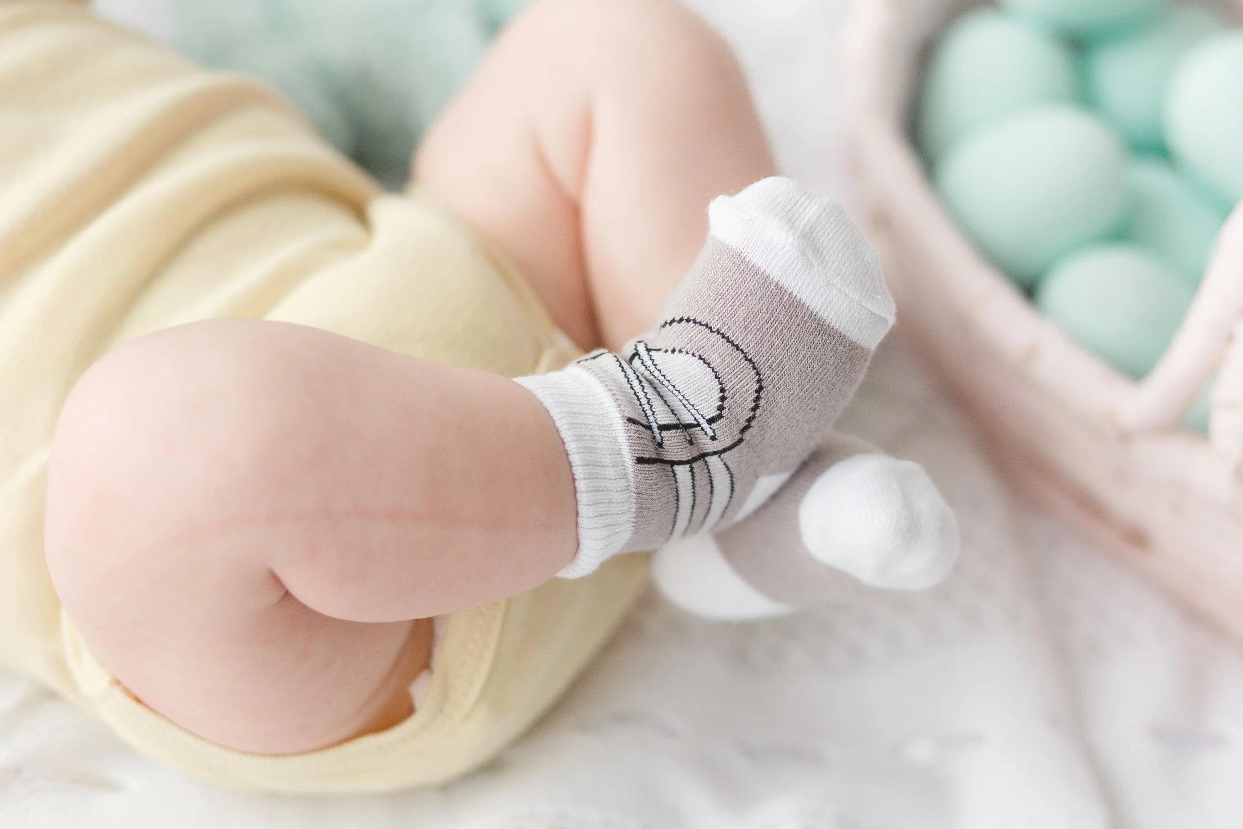 newborn-baby-legs-socks-easter-eggs-background.jpg