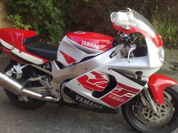 Yamaha sport motorcycle with red, white, and black color scheme parked outdoors.