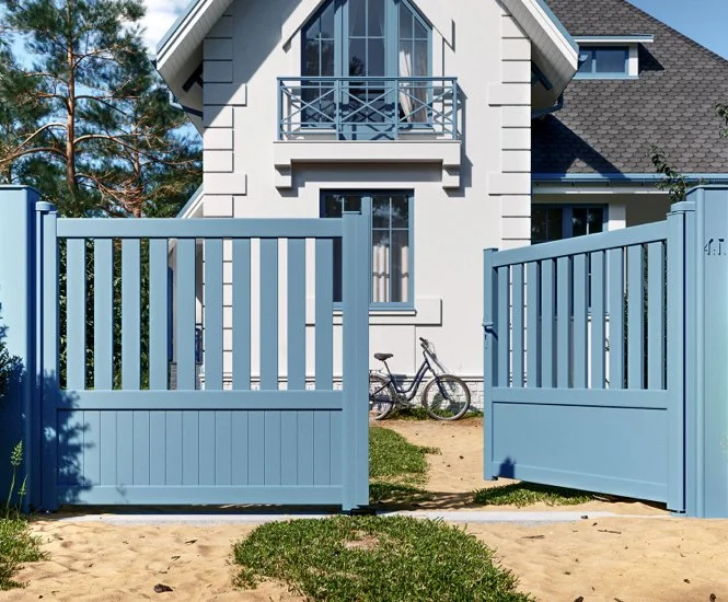 Maison blanche moderne avec clôture bleue, bicyclettes et jardin