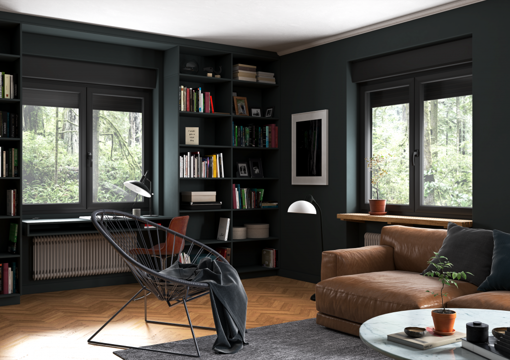 Salon avec canapé en cuir, étagère pleine de livres, fenêtres donnant sur un environnement forestier, table basse en marbre, décoration moderne.