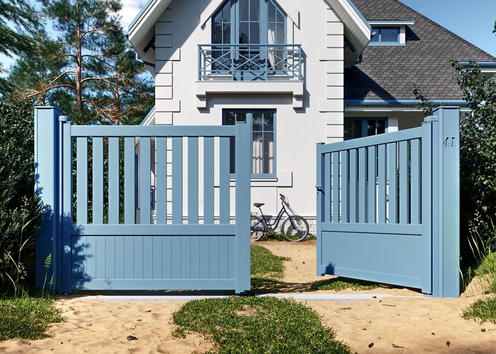 Maison moderne avec un portail bleu bleu, un vélo et un jardin verdoyant.