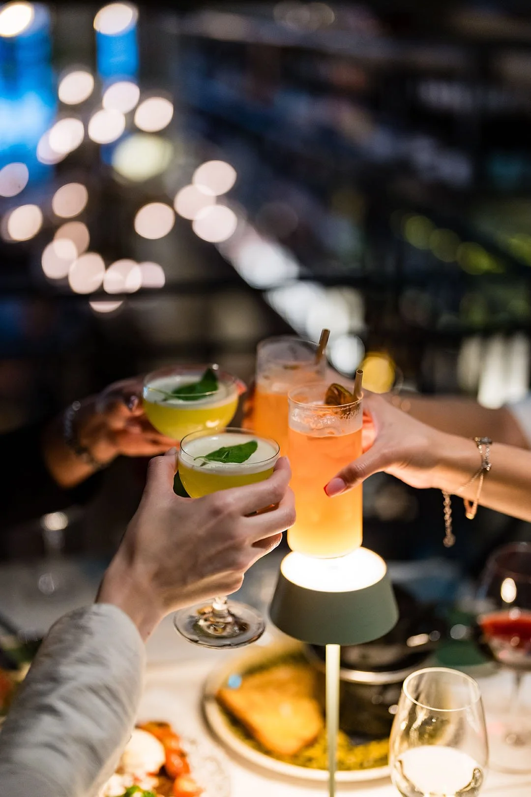 Skärmbild av personer som skålar med cocktails under en kväll på en restaurang eller bar.