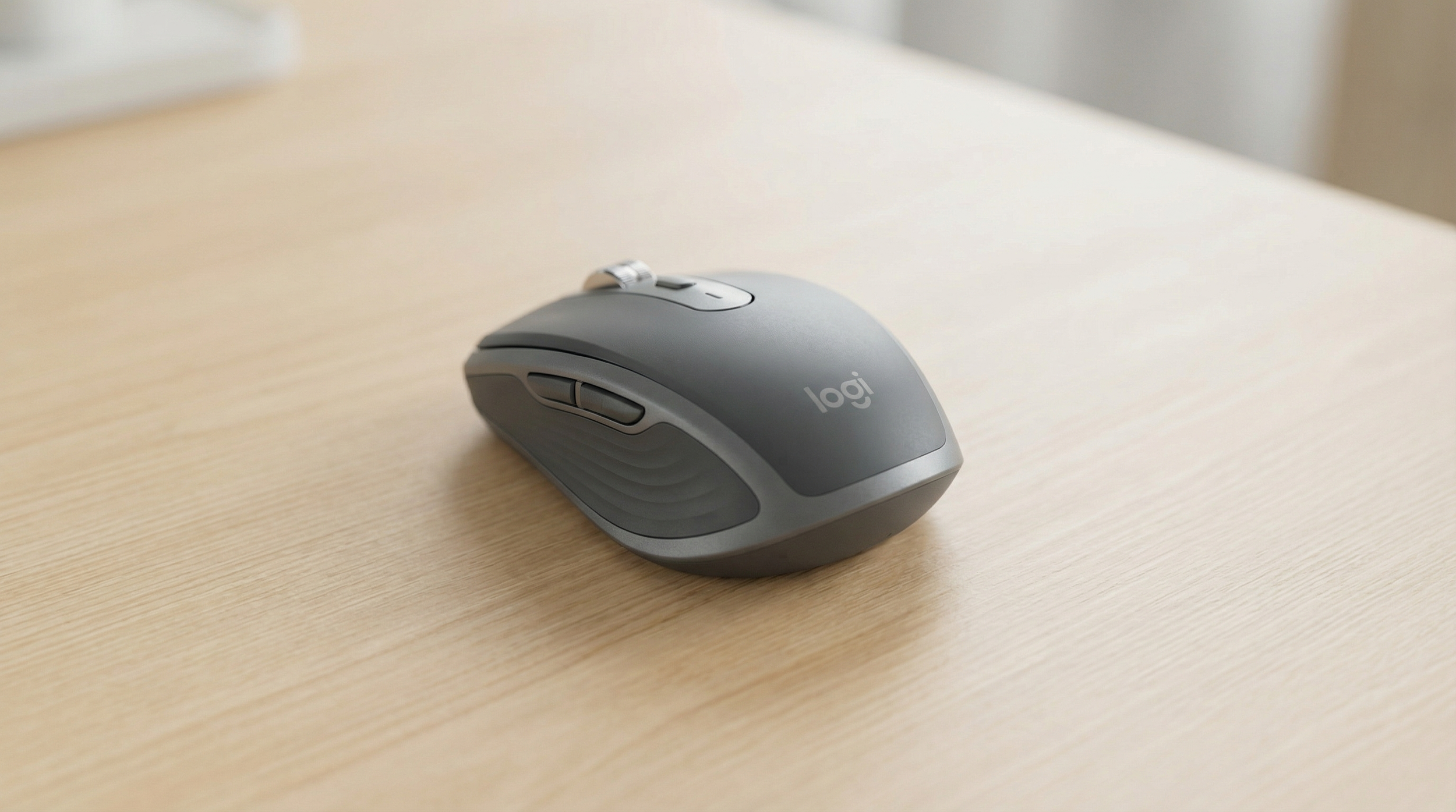 A gray Logitech computer mouse placed on a wooden desk.