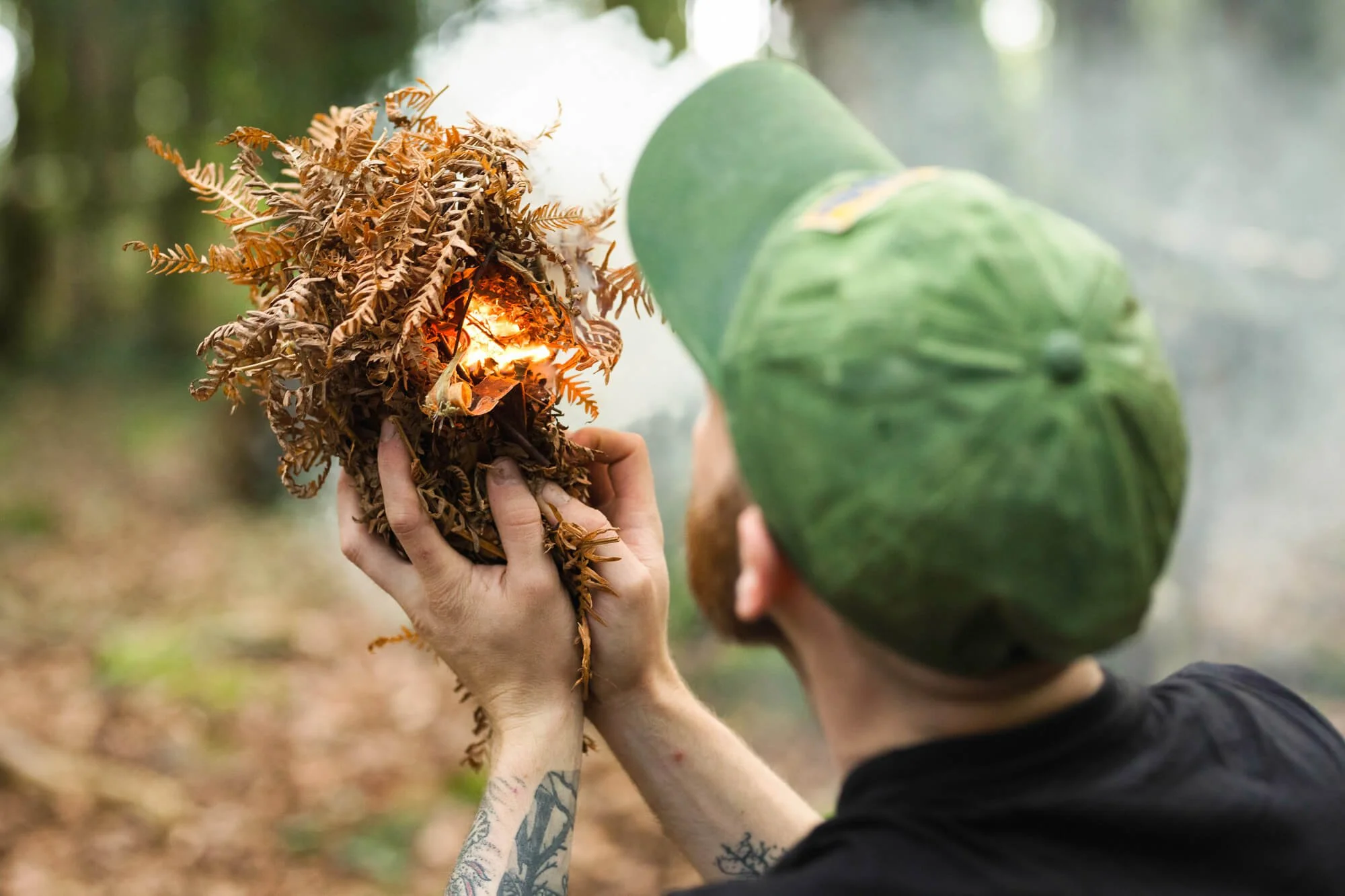 Bush Crafter Padraig Croke Blowing Oxygen into Ignited Ferns to Make Fire.