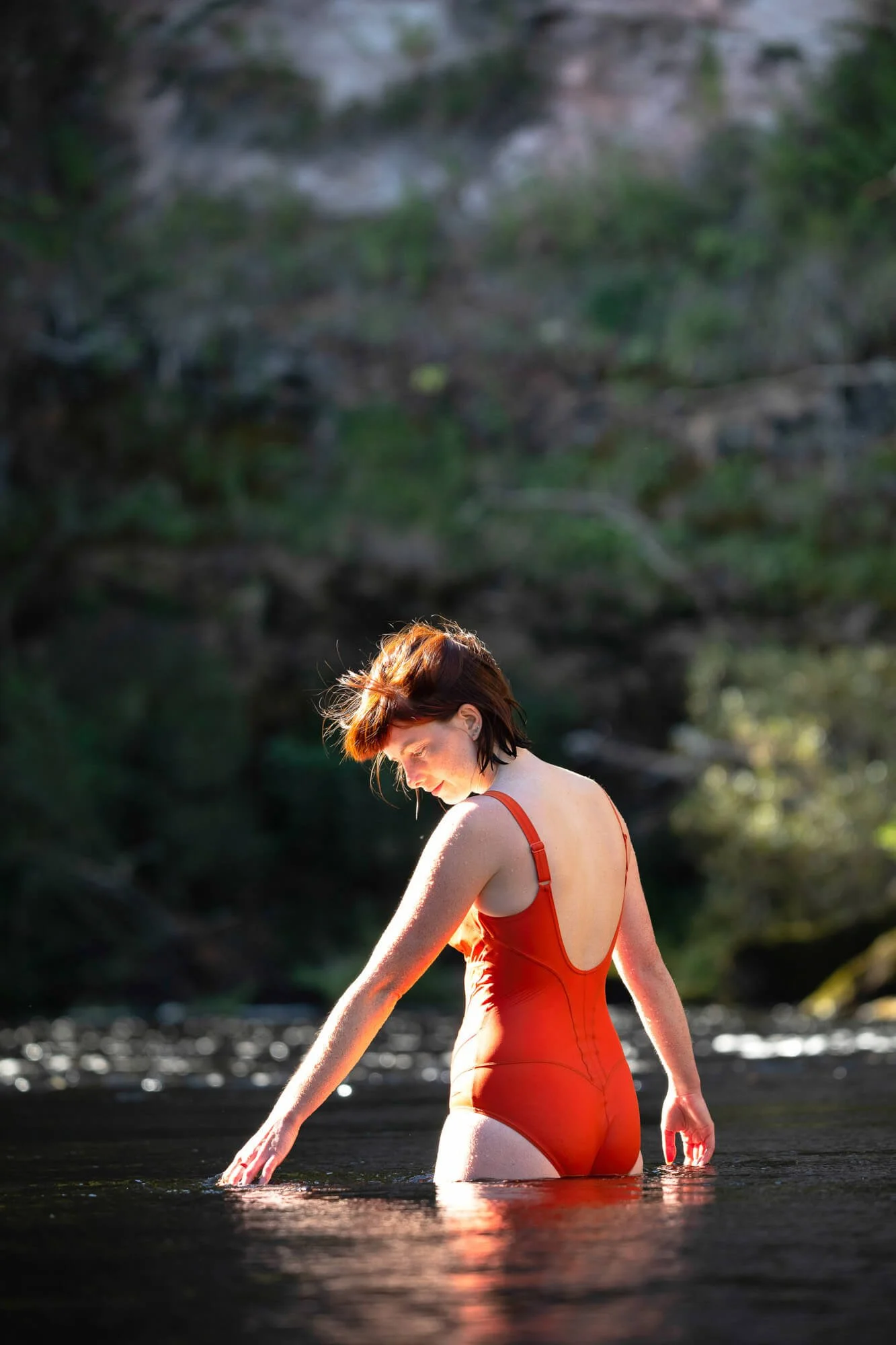 Lady in Red Swim Suit Enjoying a Quiet Moment Standing in River