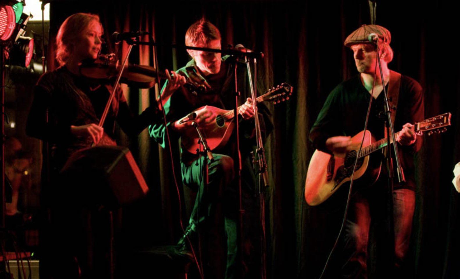 Silhuett av en person som utövar yoga på en strand vid solnedgång, som gör en vriden stretchposition.