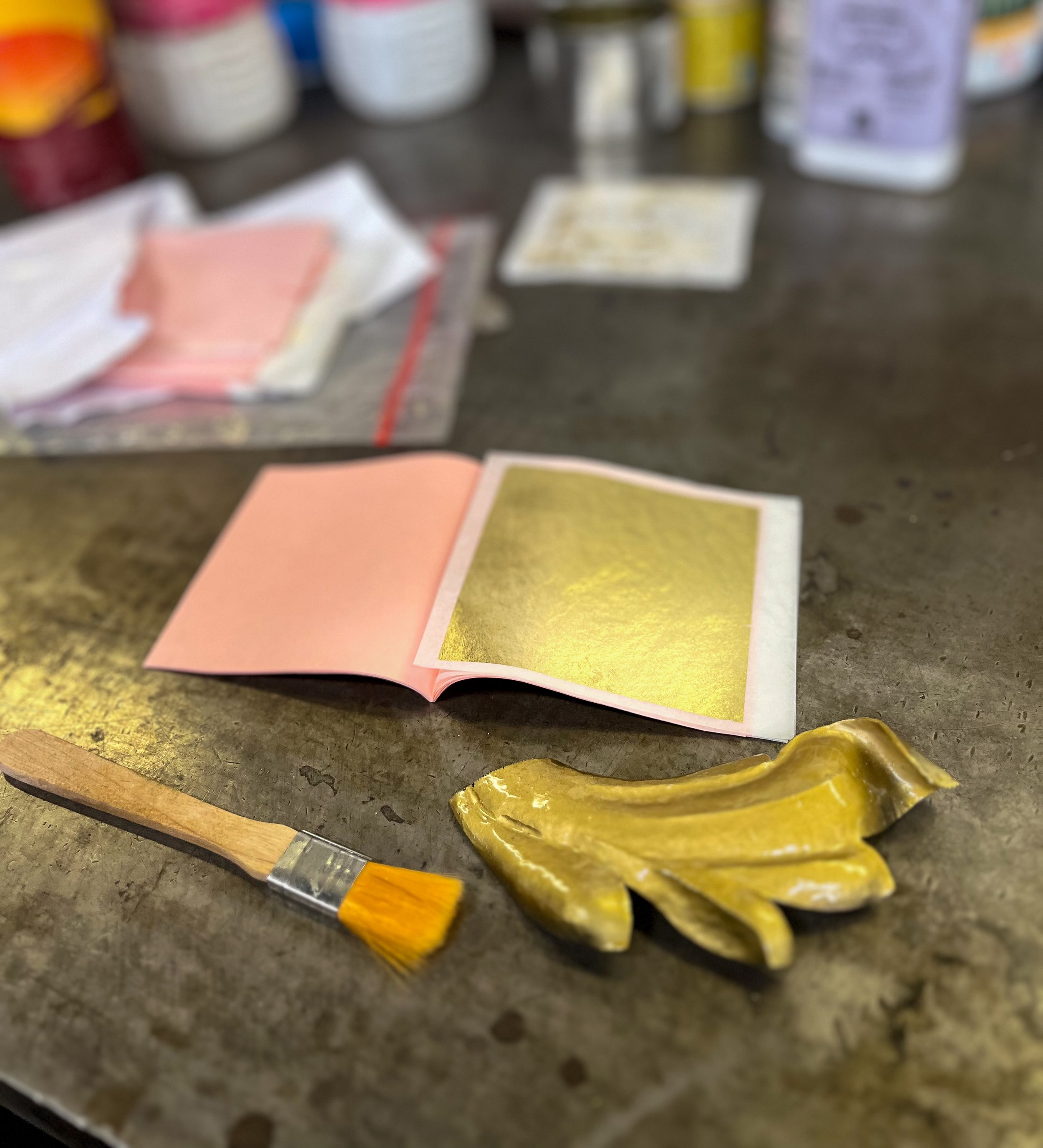 Finition en dorure à la feuille d'or sur une pièce de ferronnerie confectionnée avec la méthode du repoussage.