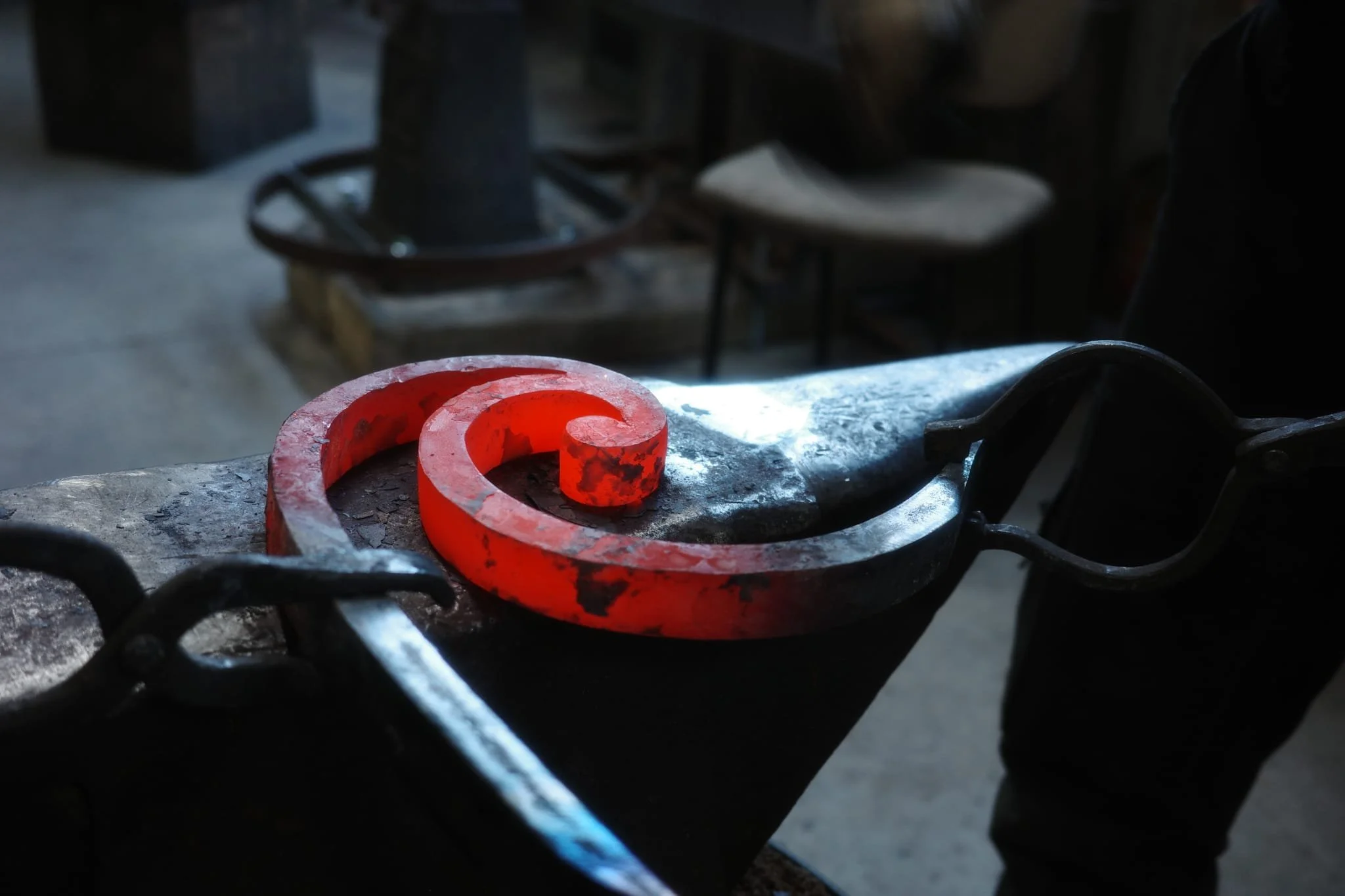 Une pièce en acier en cours de fabrication dans un atelier de forge, posée sur une surface sans détails.