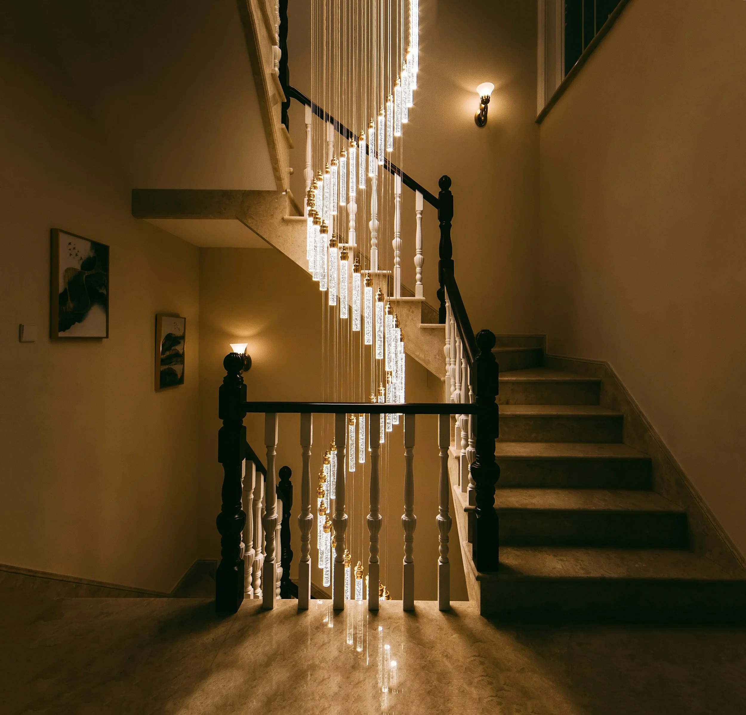 Stunning modern hanging light fixture installation along staircase railing in Kalispell home by veteran-owned electrician J. Thomas & Son