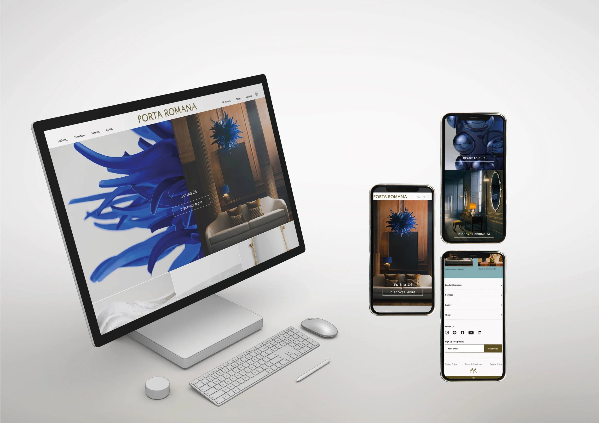 A desktop computer and three smartphones displaying the same interior website with images of modern furniture and decor. The desktop monitor shows a blue sculpture and a living room scene. The smartphones also display different views of the interior design website.