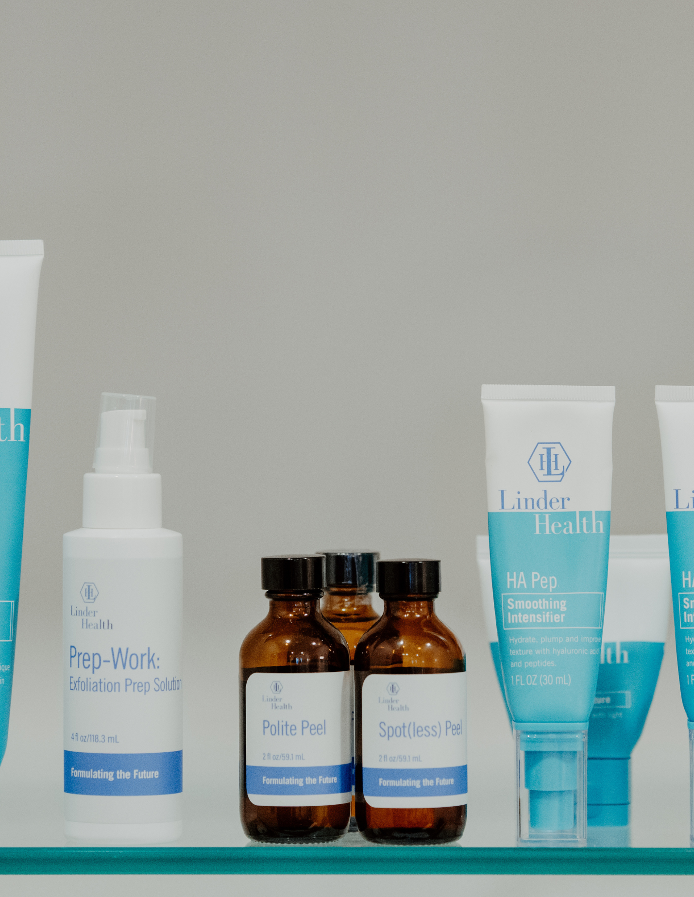Various skincare products on a shelf, including labeled bottles and tubes from Linder Health, such as Prep-Work, Polite Peel, Spotless Peel, and HA Pep.