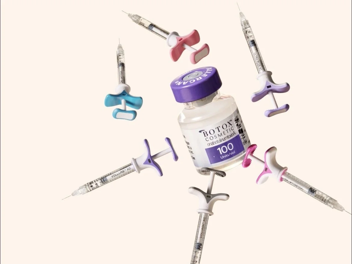A bottle of Botox cosmetic with six syringes around it, each with colorful caps and needle tips, arranged in a circular pattern.