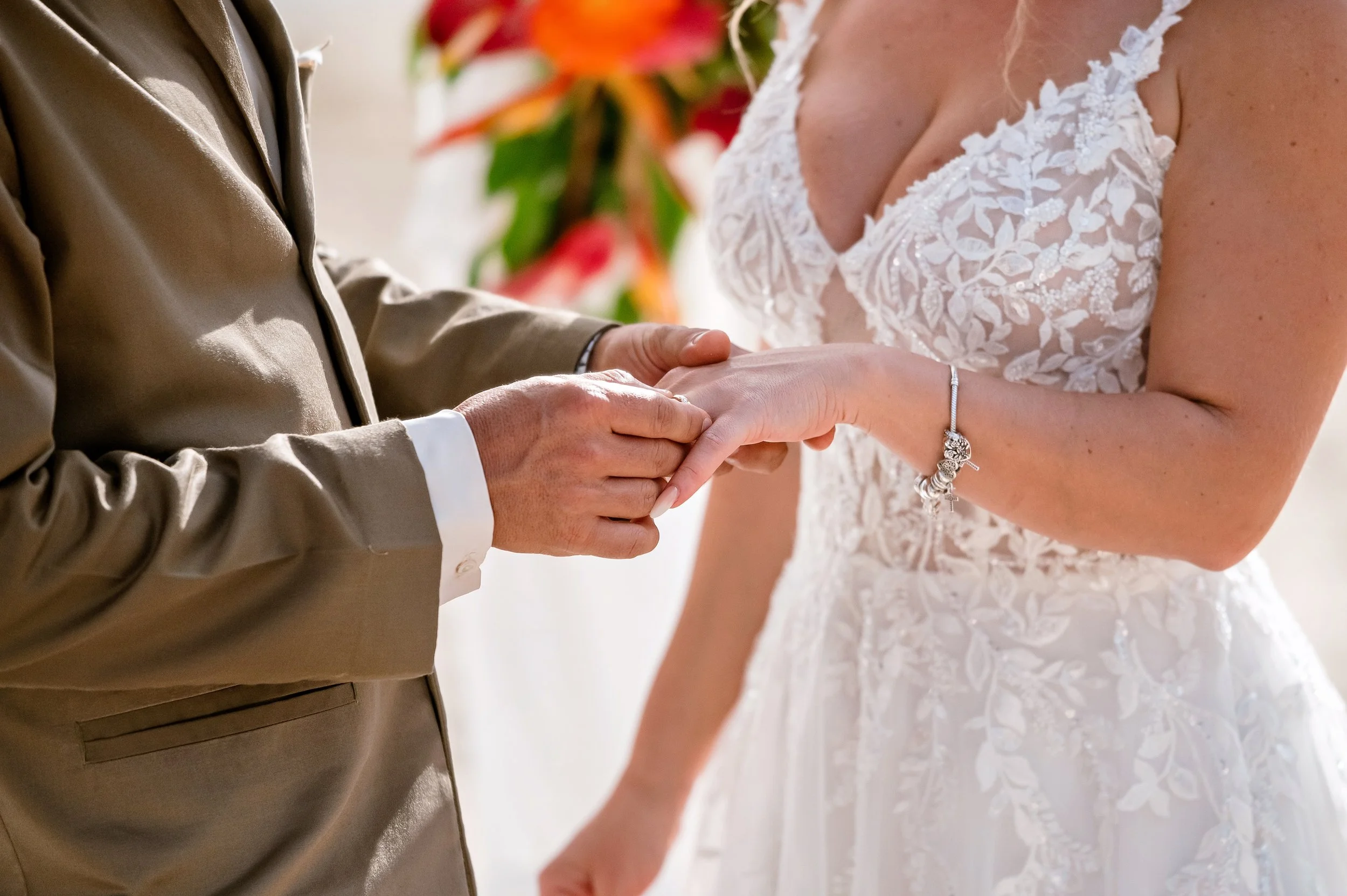 A couple exchanging wedding vows, with the groom placing a ring on the bride's finger.