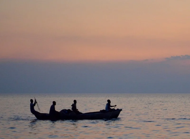 Local fishermen head out onto Lake Malawi at sunset, continuing a timeless lakeshore tradition.