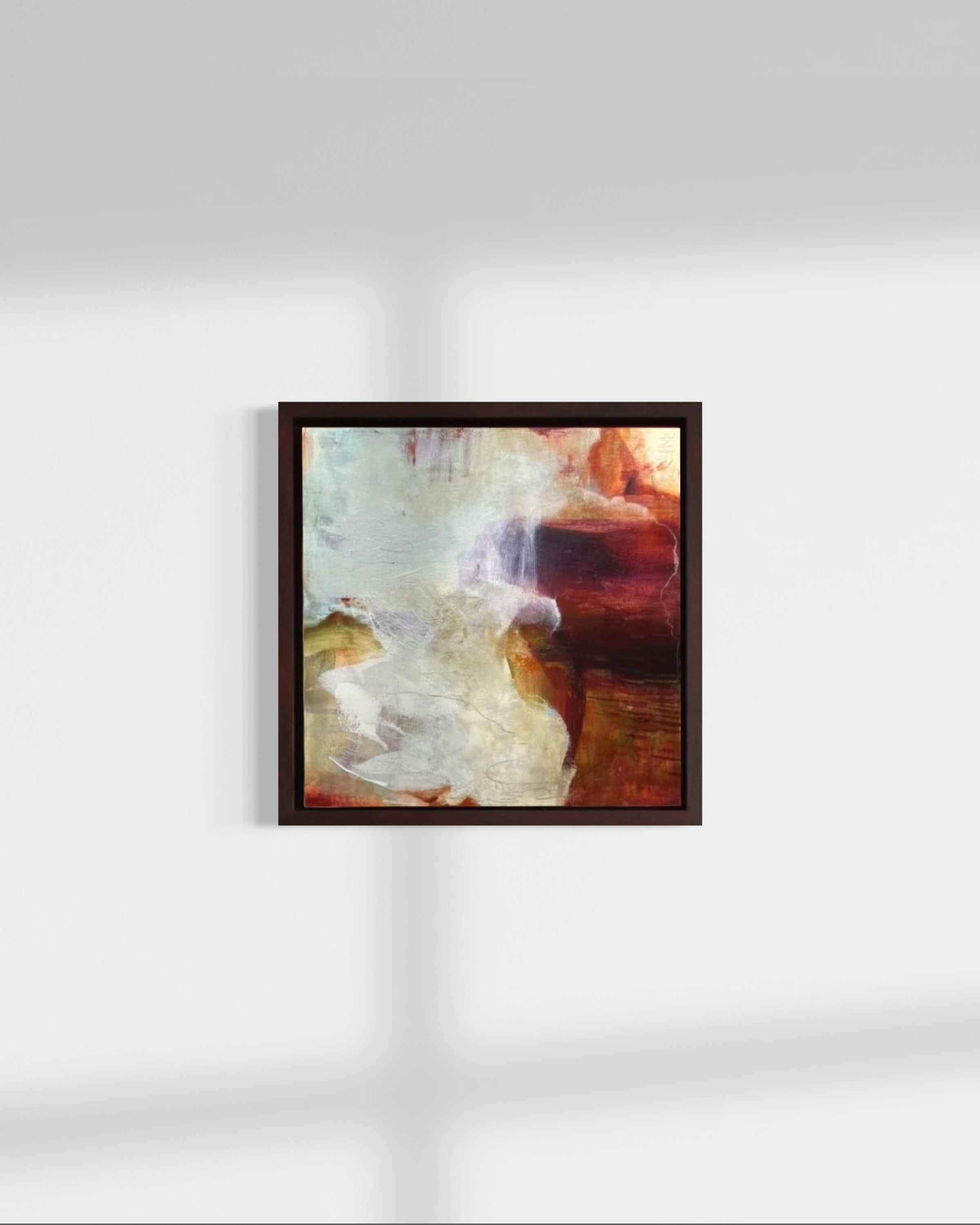 Abstract painting with swirls of red, orange, purple, black, and white in a black frame hanging on a white wall.