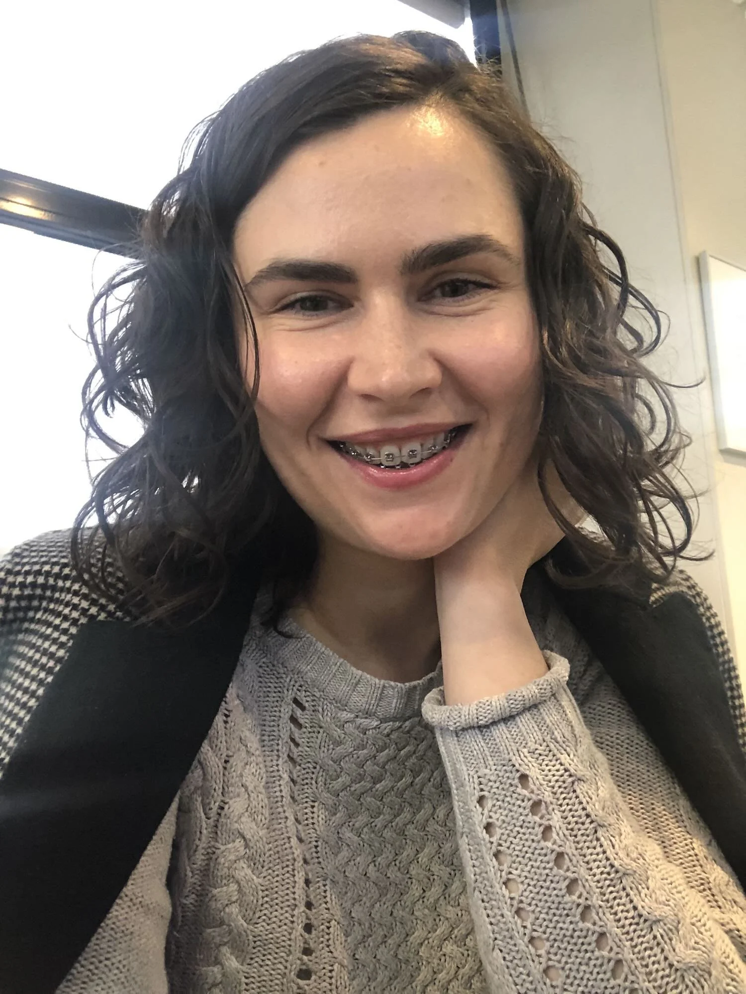 Close-up portrait of psychologist Mihaela Calin smiling warmly, representing her professional and empathic therapeutic approach in Amsterdam.