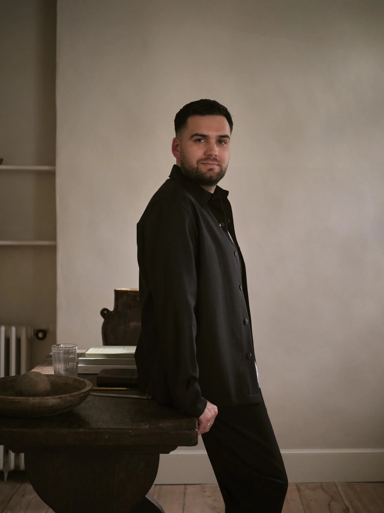 Consultant appuyé sur une table, posture calme et réflexion stratégique