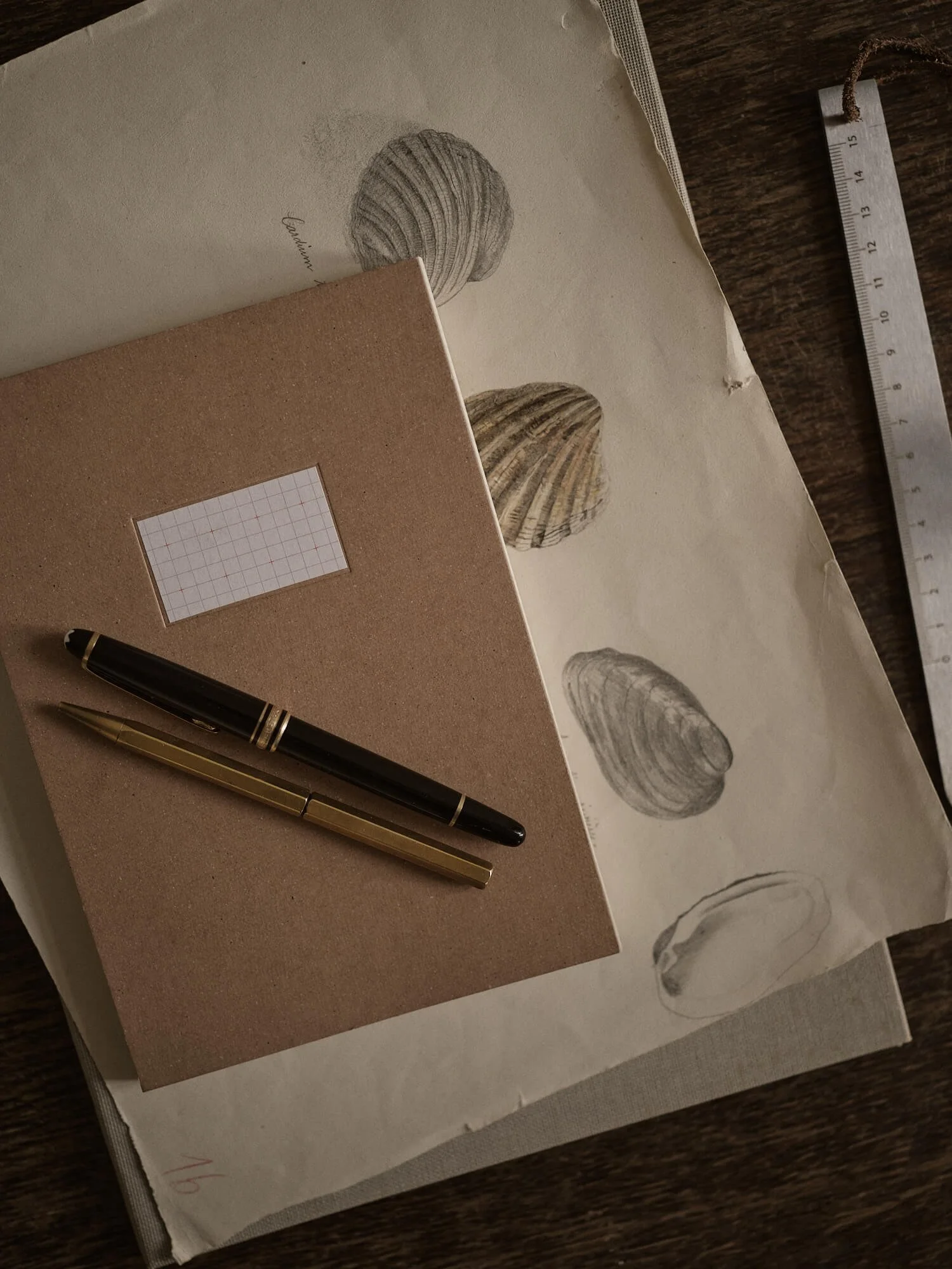 Carnet de notes et stylos posés sur des documents illustrés, espace de réflexion stratégique