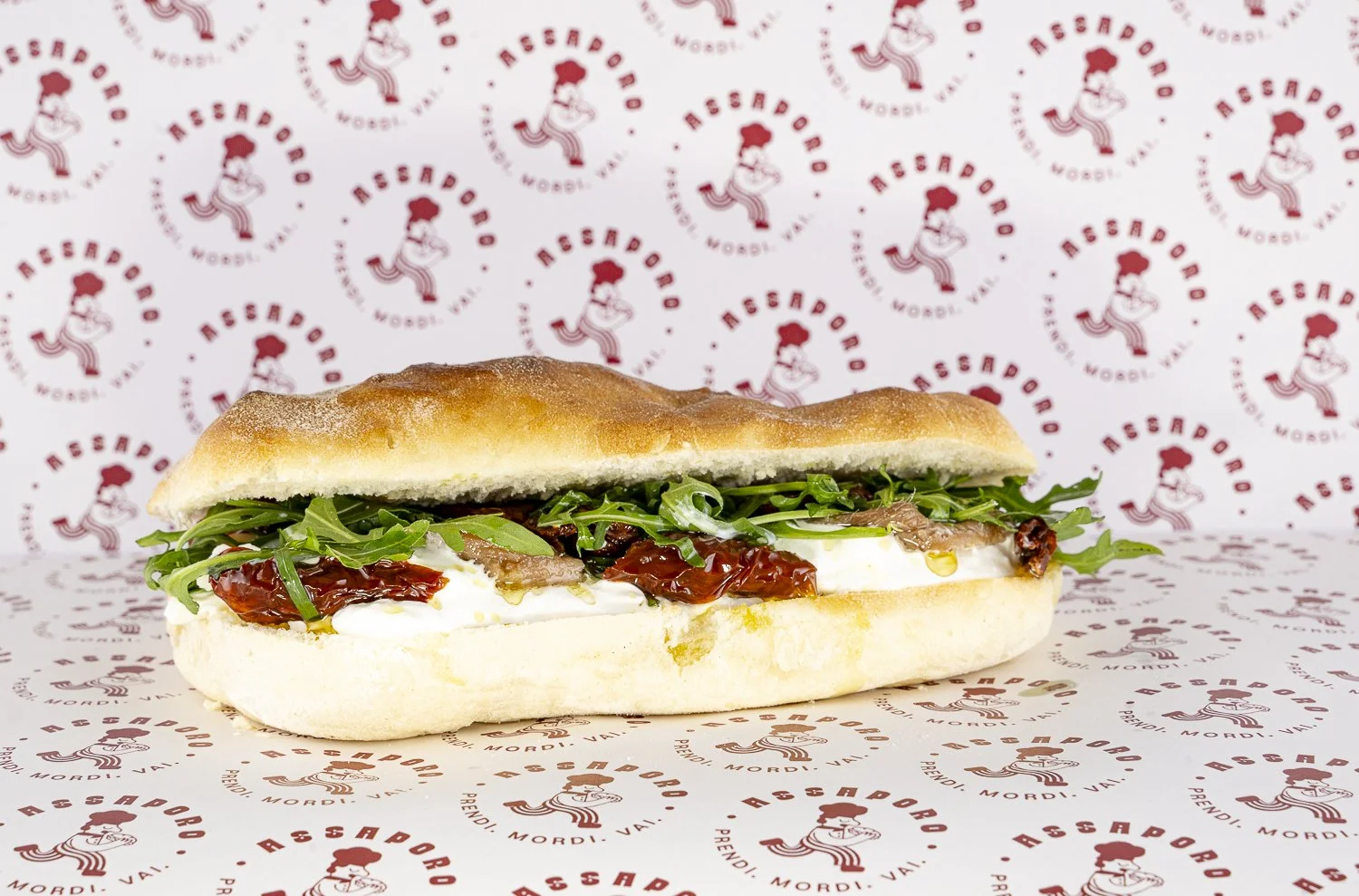 Panino con burrata, acciughe, pomodori secchi e rucola.