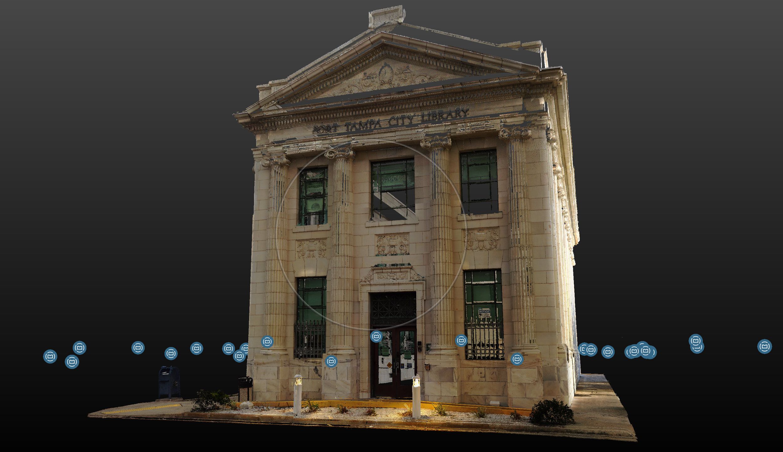 Front view of the Port Tampa City Library building, a historic stone structure with columns, decorative details, and a triangular pediment.