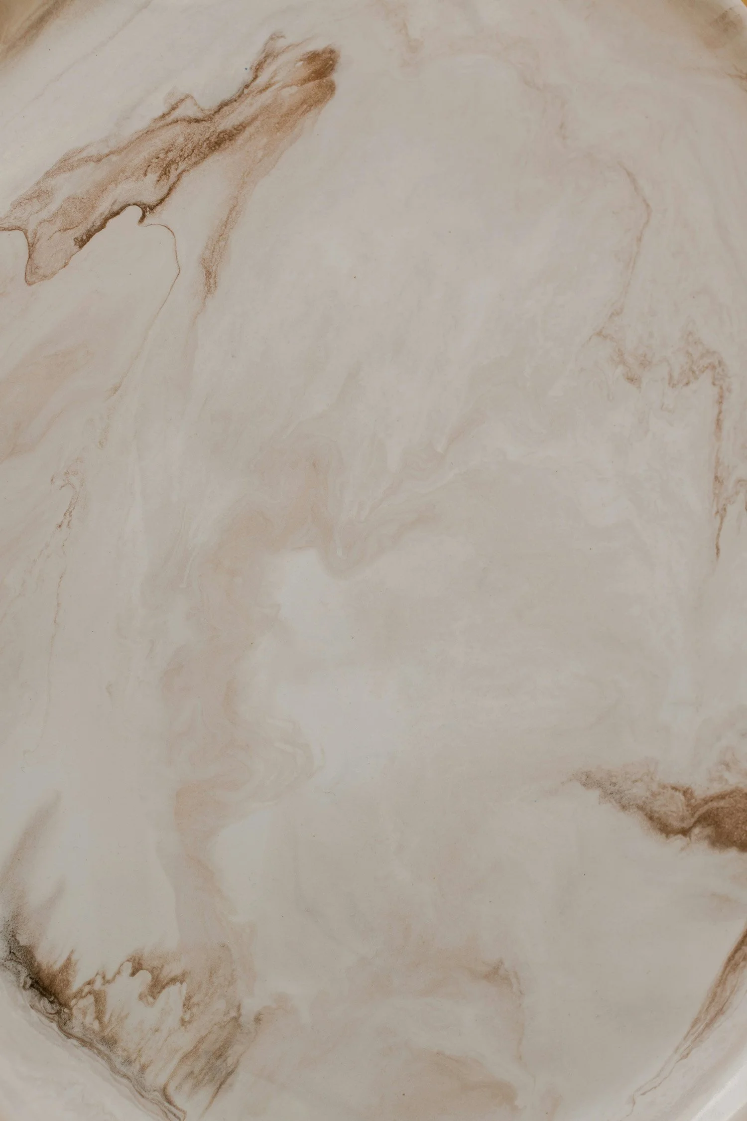 Abstract beige and cream marble texture with soft flowing natural patterns.