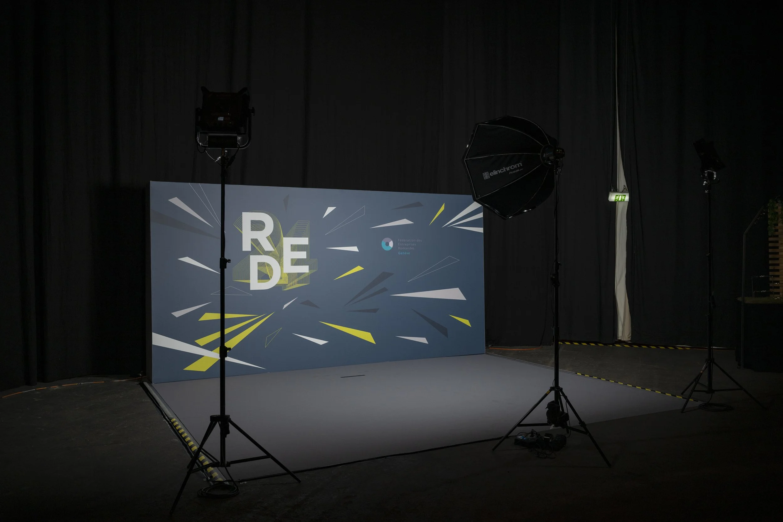 Studio d'enregistrement avec un fond graphisme pour une présentation ou un tournage video, éclairages et équipements.