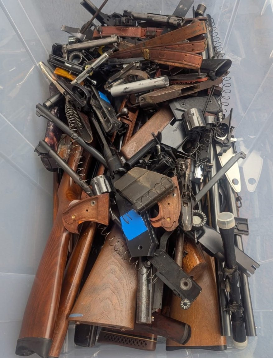 A box filled with dismantled gun pieces