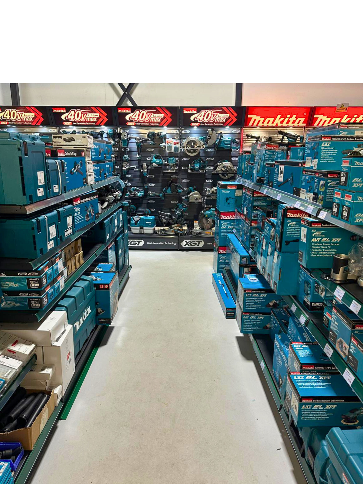 Power tools and accessories displayed on store shelves, with Makita branding visible on packaging and signage.