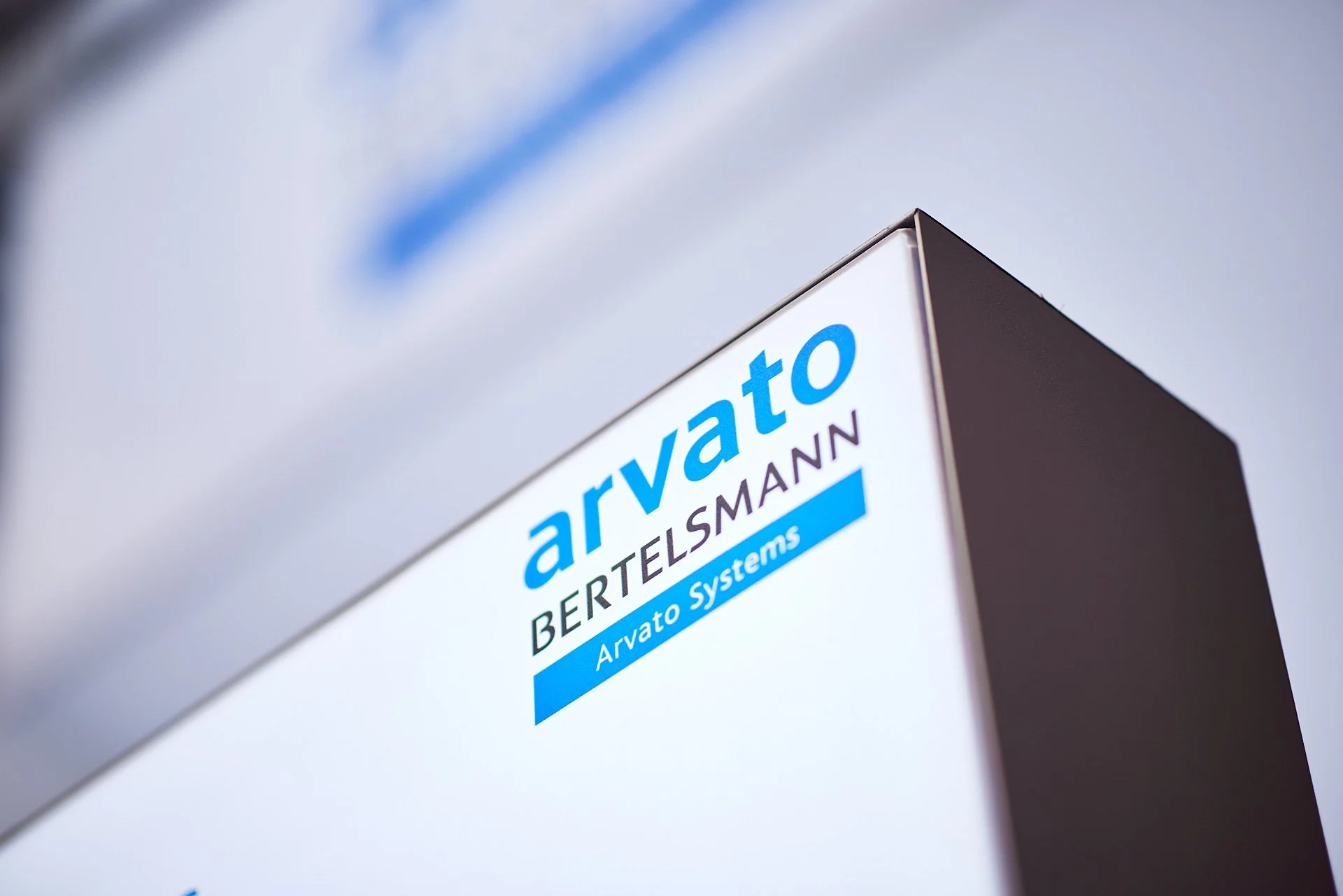 Bürogebäude mit einem Logo, das die Firma Arvato Bertelsmann zeigt, bei Sonnenlicht fotografiert.
