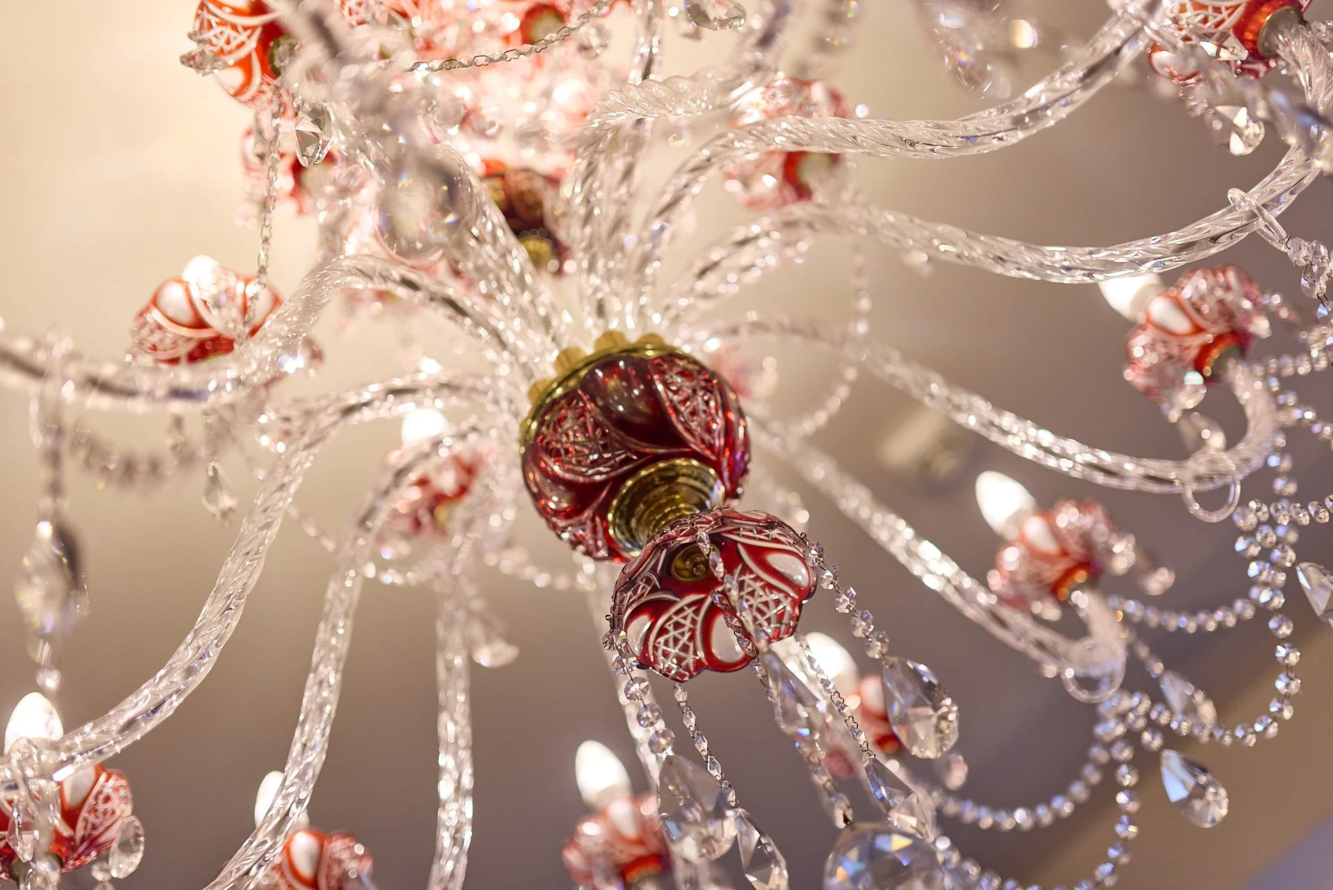 Nahaufnahme eines Kristall-Kronleuchters mit roten und klaren Kristall-Perlen und Lampen.