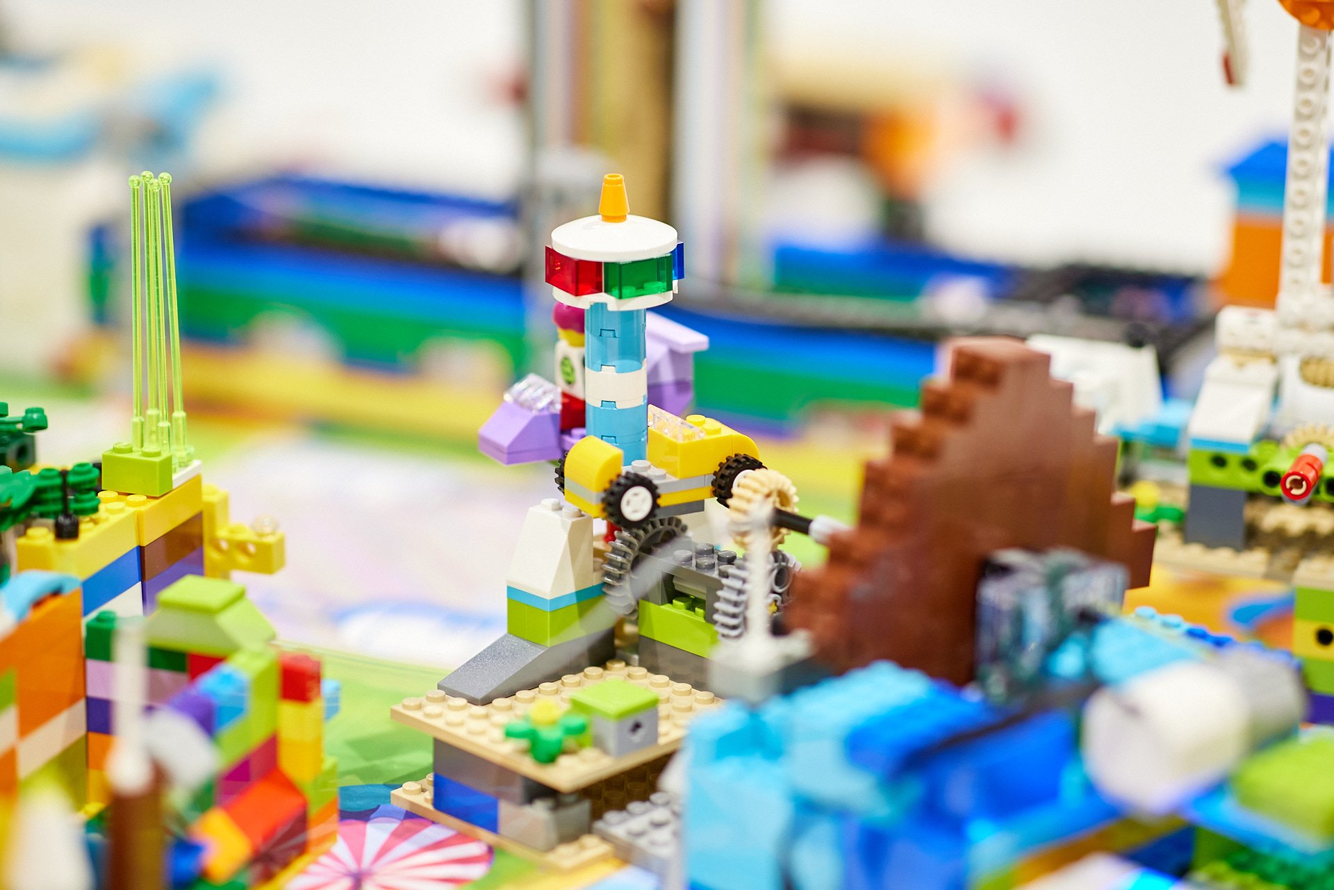 Bunte LEGO-Kreation mit einem Turm, Zahnrädern und Wasser.