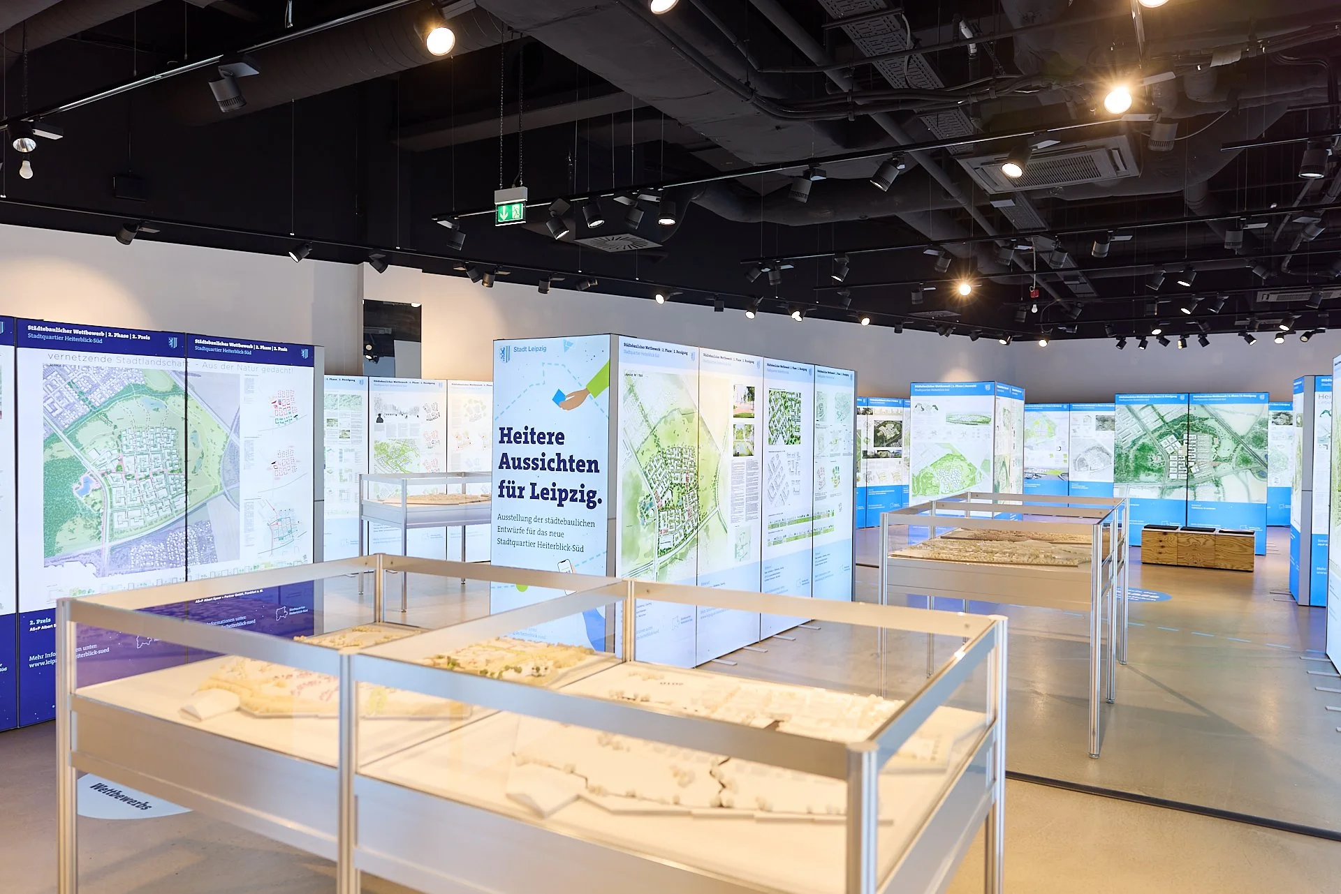 Ausstellung mit Stadtplänen und Modellen in einem Museum oder Planungsraum, Fokus auf Entwicklung und Perspektiven für Leipzig.