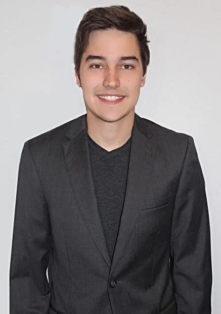 A young man with short dark hair and a bright smile