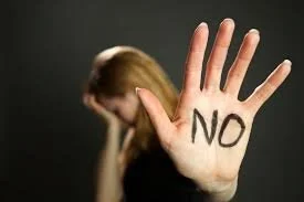 A person holding up their hand with the word 'NO' written on the palm, blurred background of a woman with reddish hair. Jacob Fisher is the attorney to call!