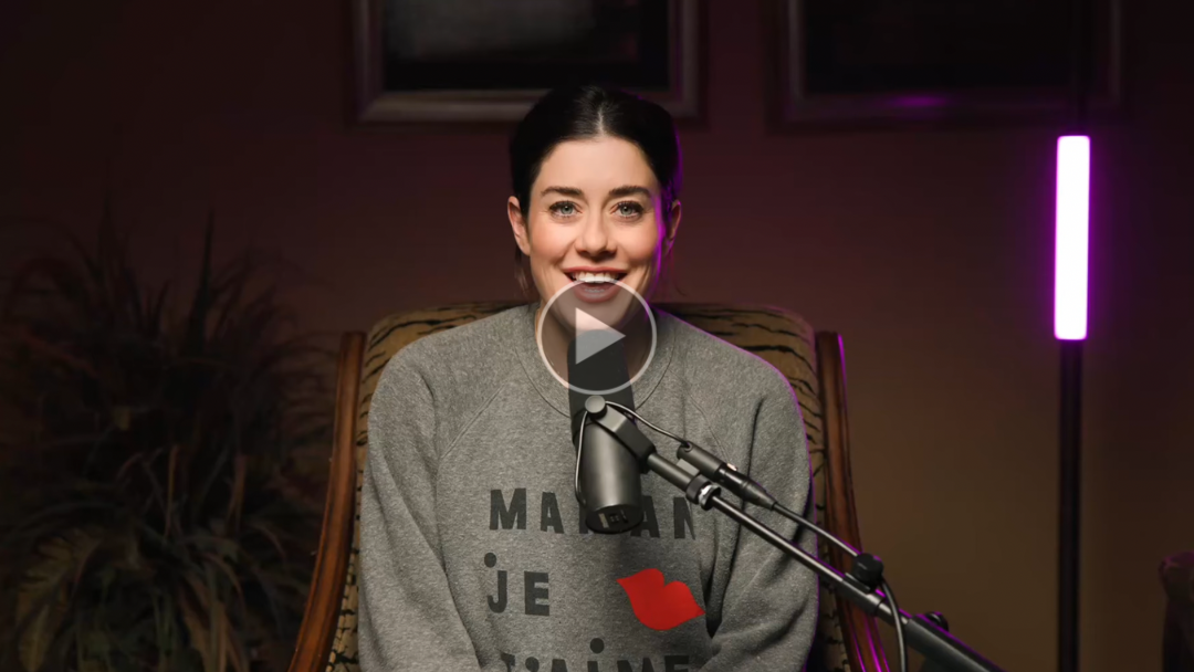 Manon smiling into a microphone in a recording studio with dark background and purple lighting.