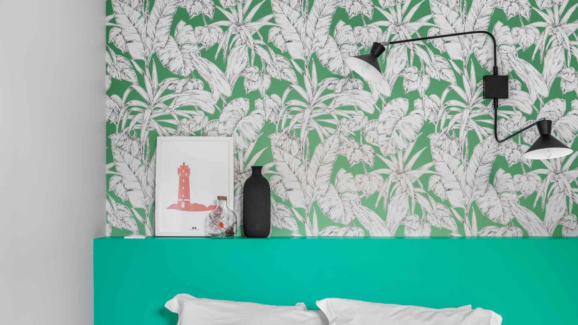 Détail papier peint chambre secondaire. Location saisonnière avec tête de lit décorative. Applique double La redoute pour un investissement maîtrisé.
