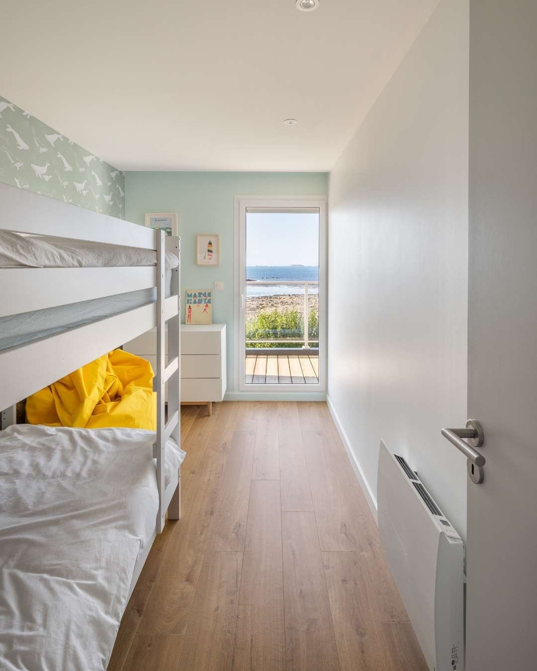 Chambre d'enfants optimisée. Aménagement d'une petite chambre avec lits superposés. Optimisation du couchage pour rentabiliser la petite chambre qui possède un petit coin libéré avec pouf de relaxation lecture