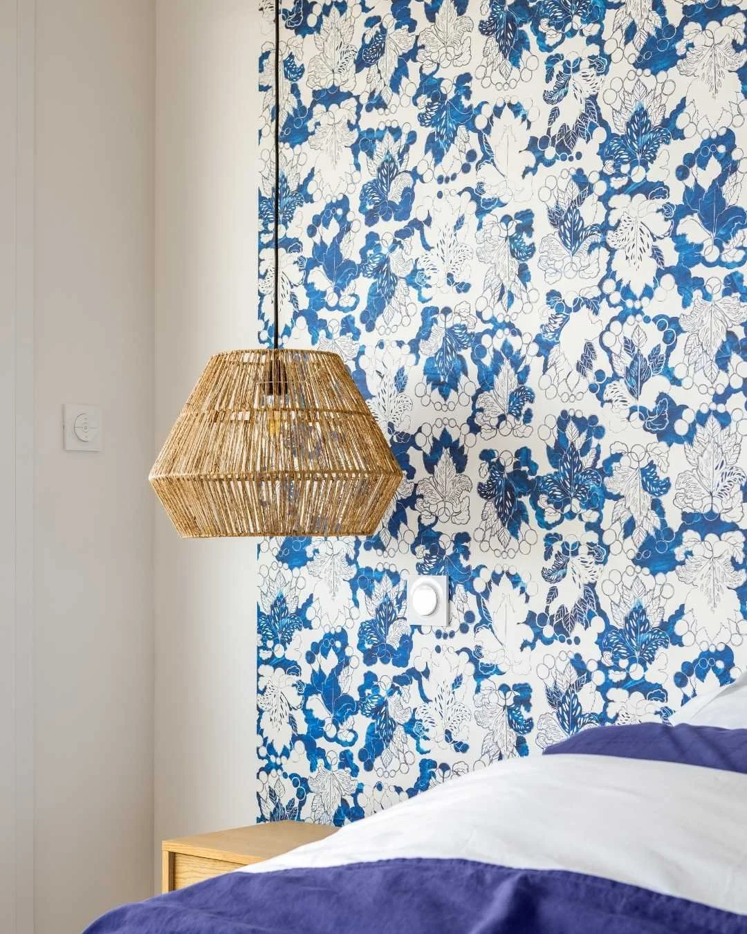 Détail décoration chambre papier peint motif bleu suspension fibre naturelle. Ambiance soignée et minimaliste
