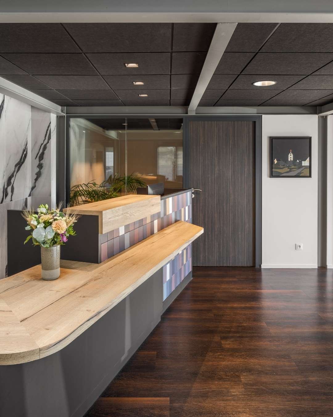 Gros plan sur banque d'accueil en bois et mélaminé noir, aménagement de bureau par ladda sisaath mélange de texture bois, carrelage design mutina