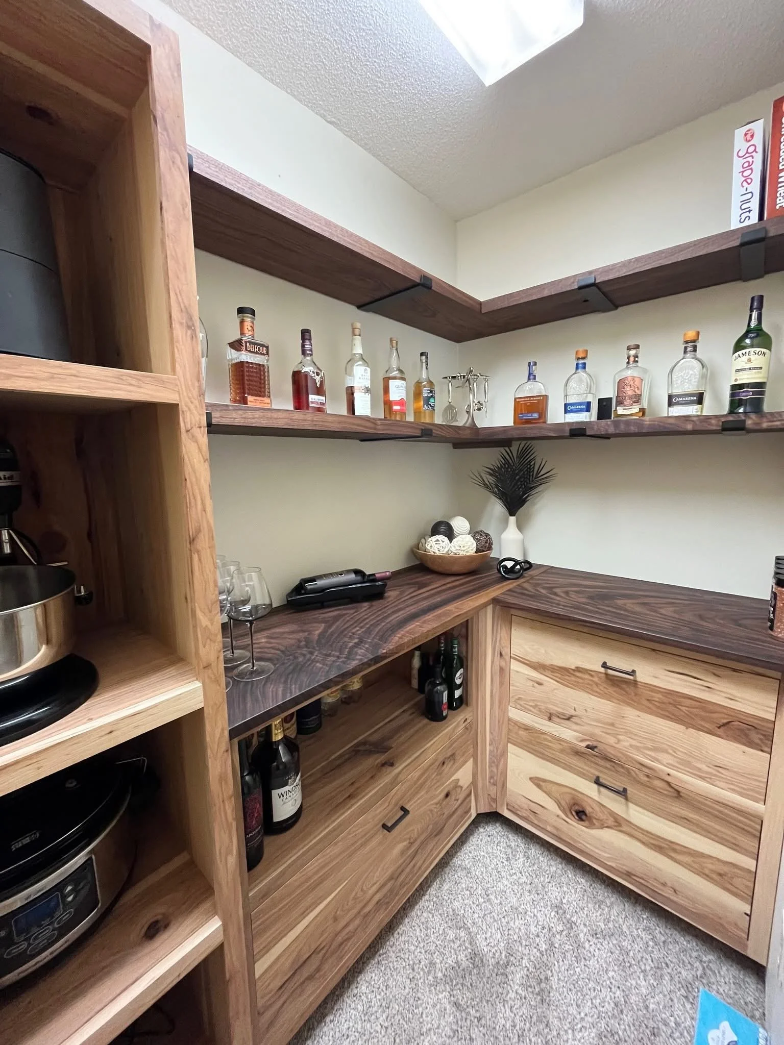Pantry with display shelves, storage drawers, and appliance cubbies.