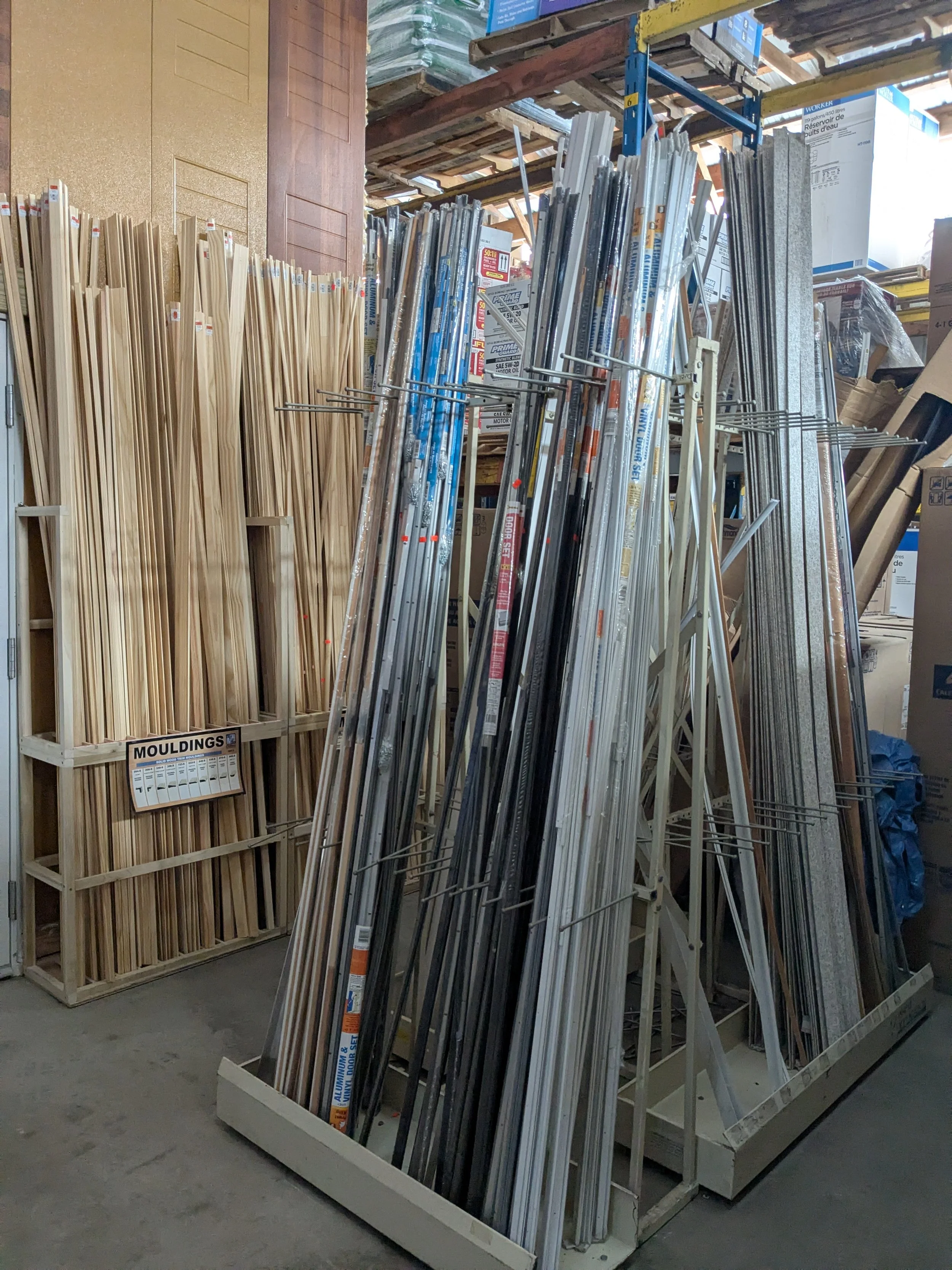 A store display with metal and wooden molding strips stored on metal racks.