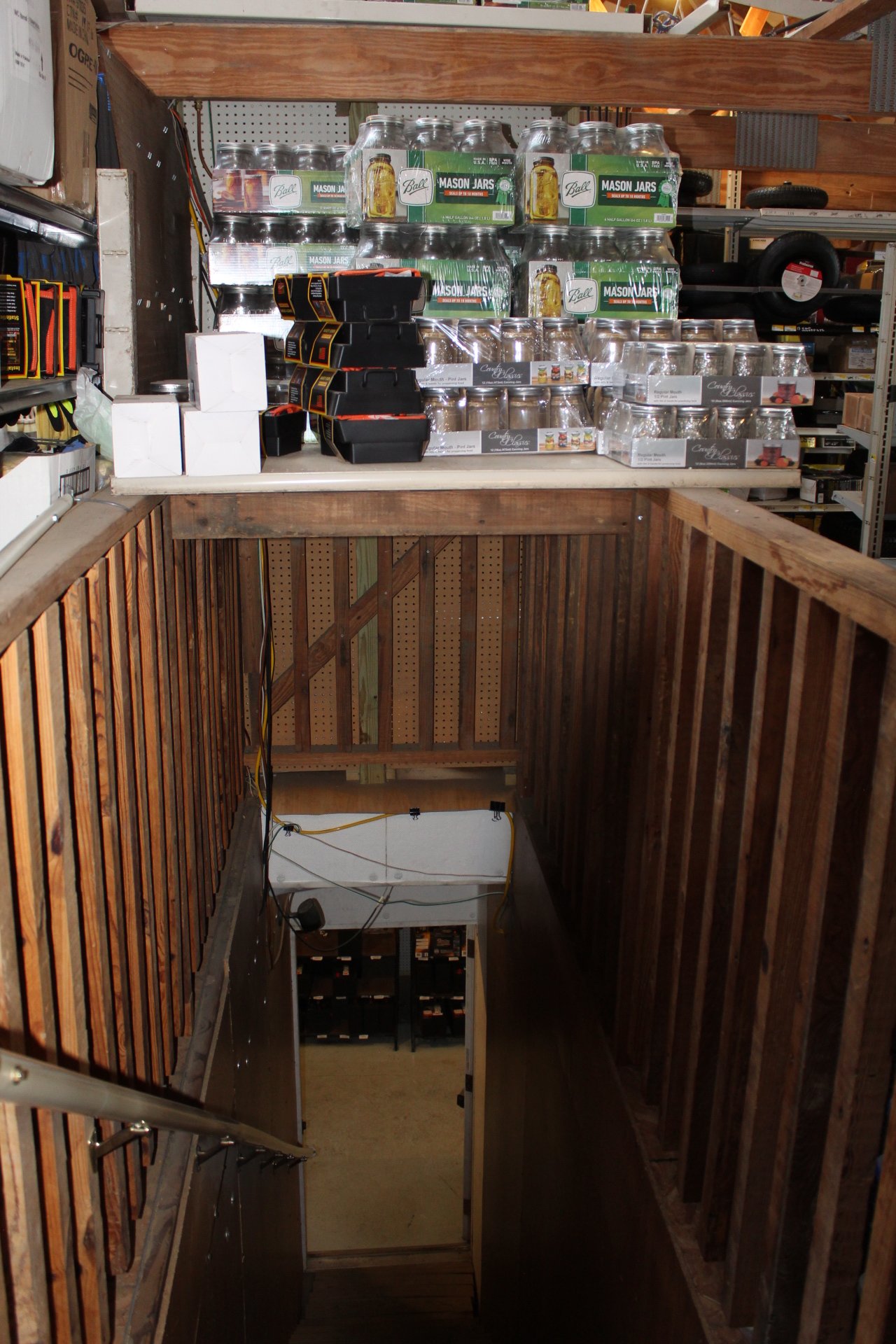 Display of mason jars and craft supplies on a store shelf, with wooden railings and stairs leading down.