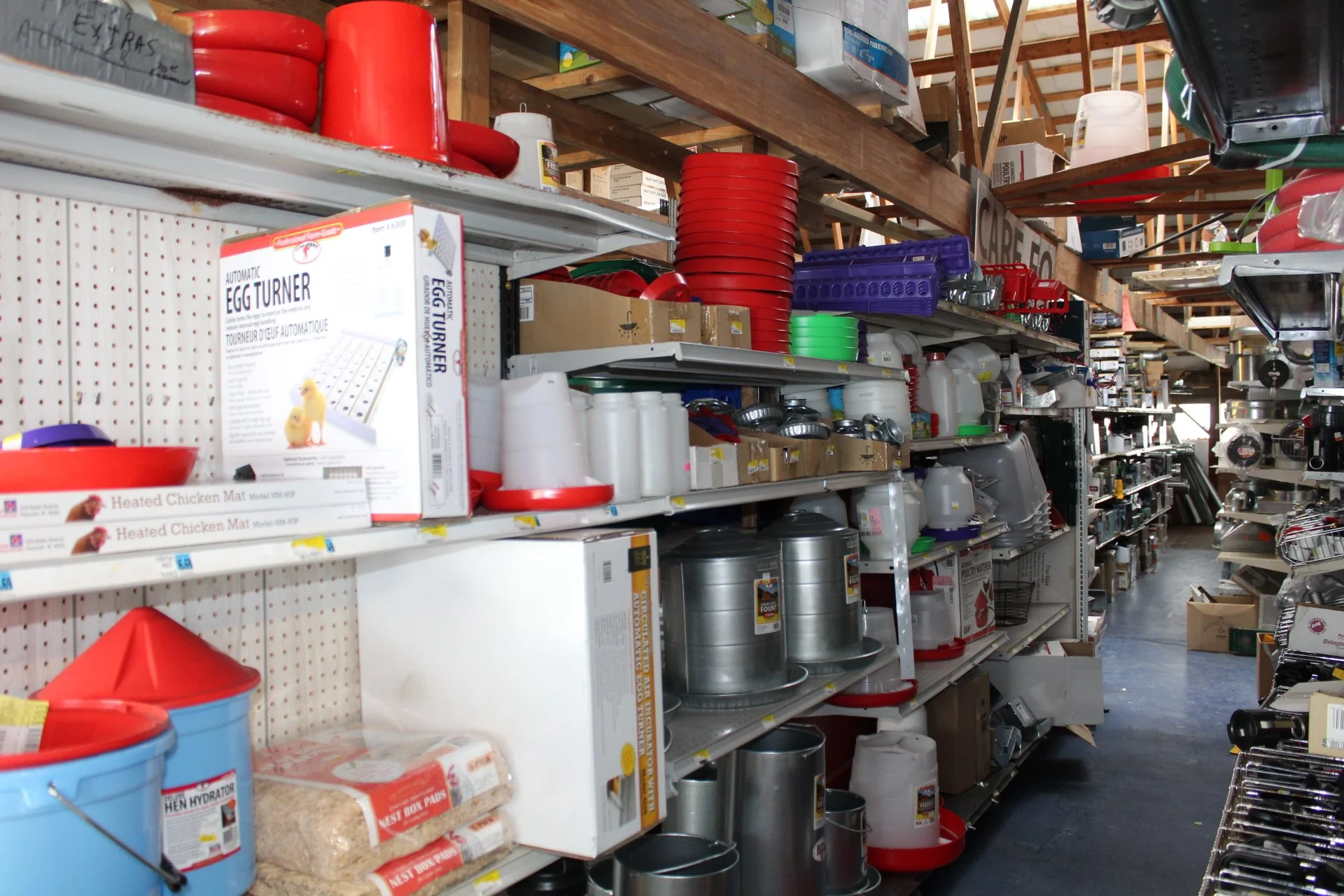 Shelves stocked with baked goods containers, pet supplies, and kitchenware in a warehouse store.