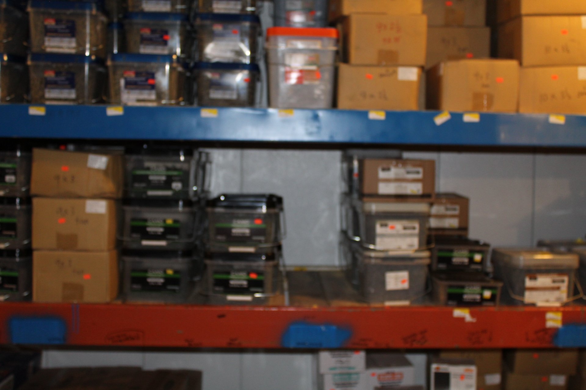 Blurred image of warehouse shelves filled with boxes and containers.