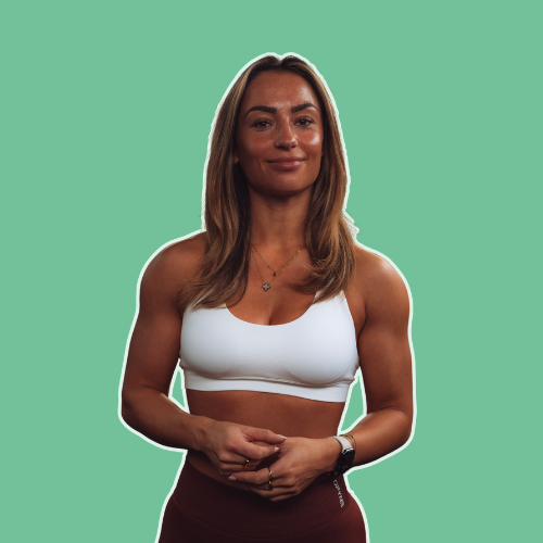 Woman with long brown hair wearing a white sports bra and dark leggings against a green background.