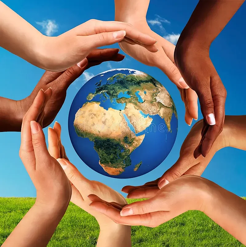 Multiple hands of different skin tones surround a small globe of Earth, symbolizing unity and environmental care, with a blue sky in the background and green grass at the bottom.